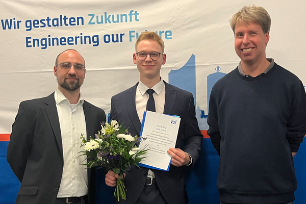 Portraitfoto, Preisträger halt Blumen und Urkunde in der Hand