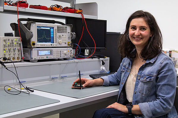 Lydia Schott, Promovendin in der Fakultät ING, hält in ihrer Hand eines ihrer Forschungsobjekte, einem ihrer Forschungsobjekte, den Prototyp eines Funkmoduls mit Wake-up Receiver 