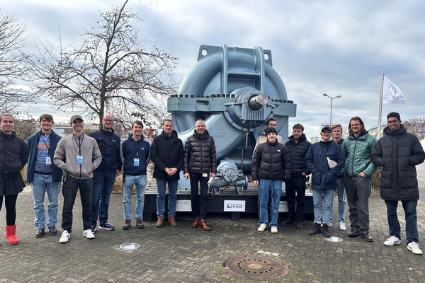 Gruppenfoto der Studierenden vor großer Pumpen auf dem Außengelände der Firma