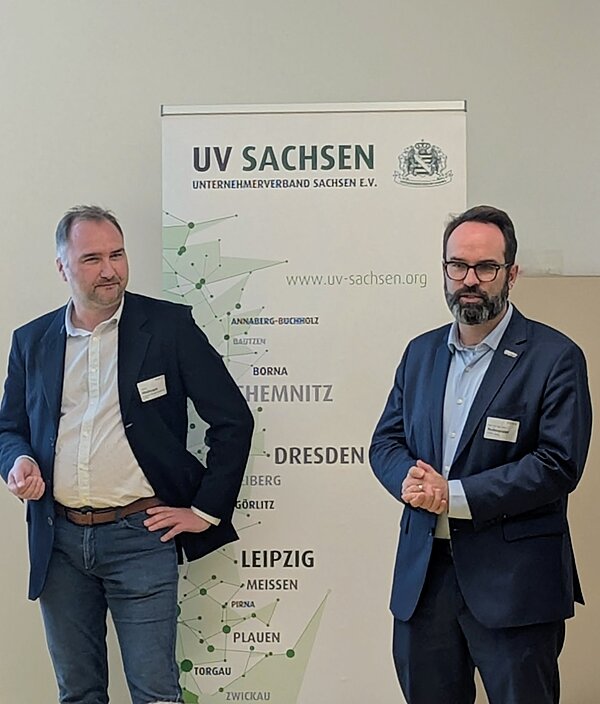 zwei Herren von Flipchart berichten etwas