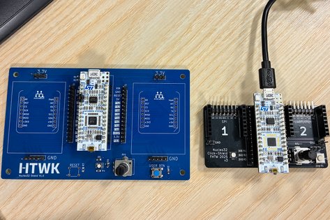 Nahaufnahme eines Microcontrollers, blaue Platine mit HTWK Logo