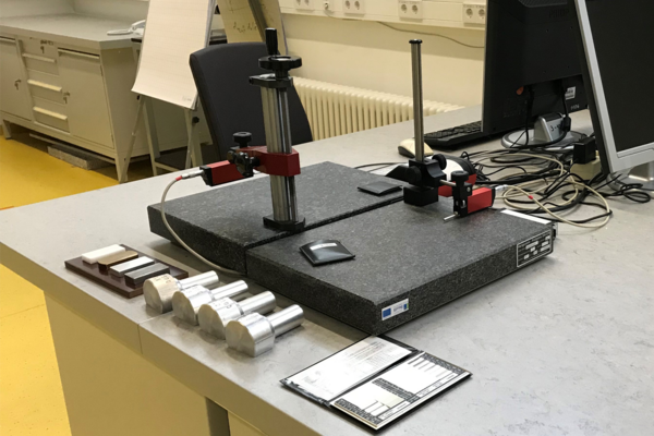 Photo of a workspace, with a measuring device on the table and various attachments in front of it