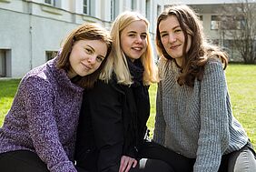 drei junge Frauen auf Wiese