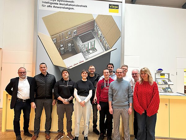 Gruppenfoto, im Hintergrund Skizze an Wand und Viega-Logo