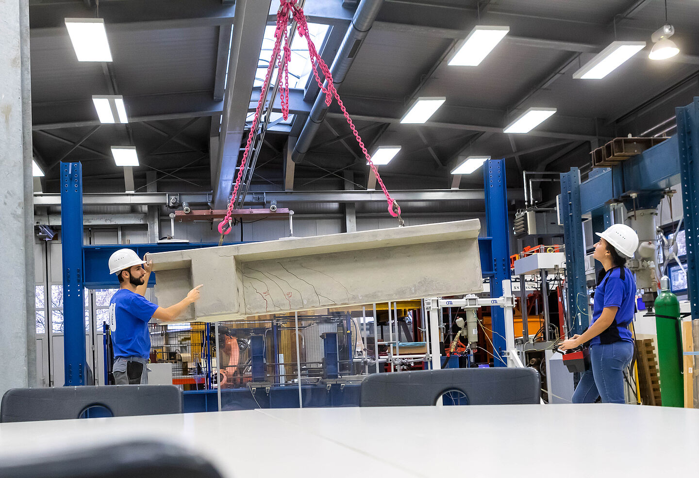 Blick in die Bauversuchshalle der Fakultät Bauwesen der HTWK Leipzig. (Foto: Swen Reichhold/HTWK Leipzig) zwei Personen mit Helm in einer großen Halle