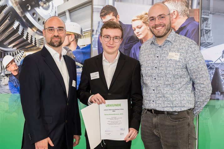 Group photo; the award winner in the center is holding the certificate in his hands
