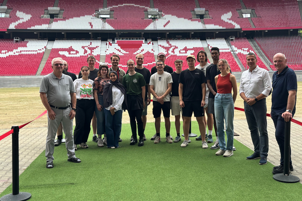Gruppenfoto im RB Stadion im Hintergrund die Tribüne mit RB Logo in weiß