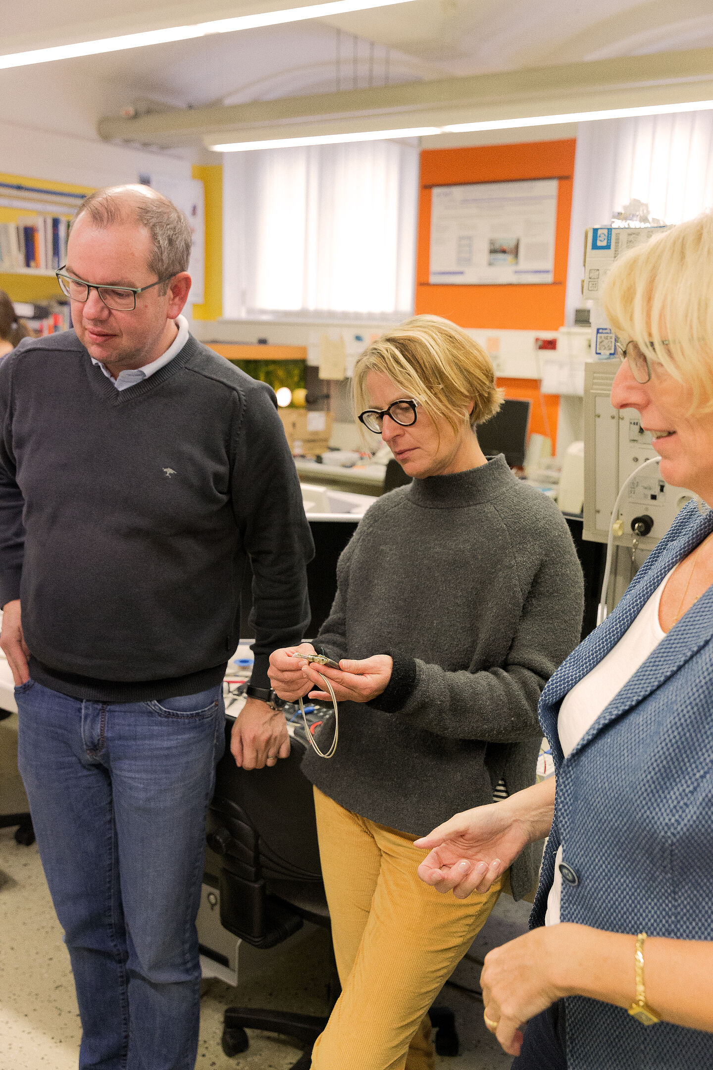 Das Foto zeigt eine Lehrerin, die einen Herzschrittmacher in ihrer Hand betrachtet.