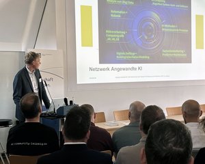 Ein Mann hält einen Vortrag und schaut zur Präsentation