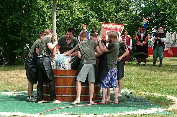 So geht Gautschen Eine Person wird festgehalten und in ein Becken voller Wasser getaucht