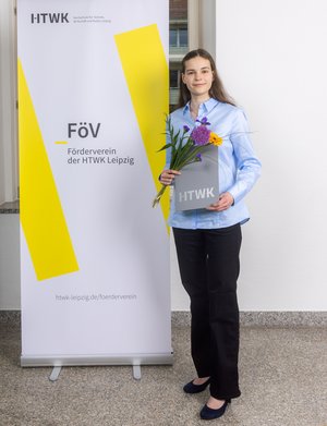 Isabell Schäker Frau in dunkler Hose vor Plakat