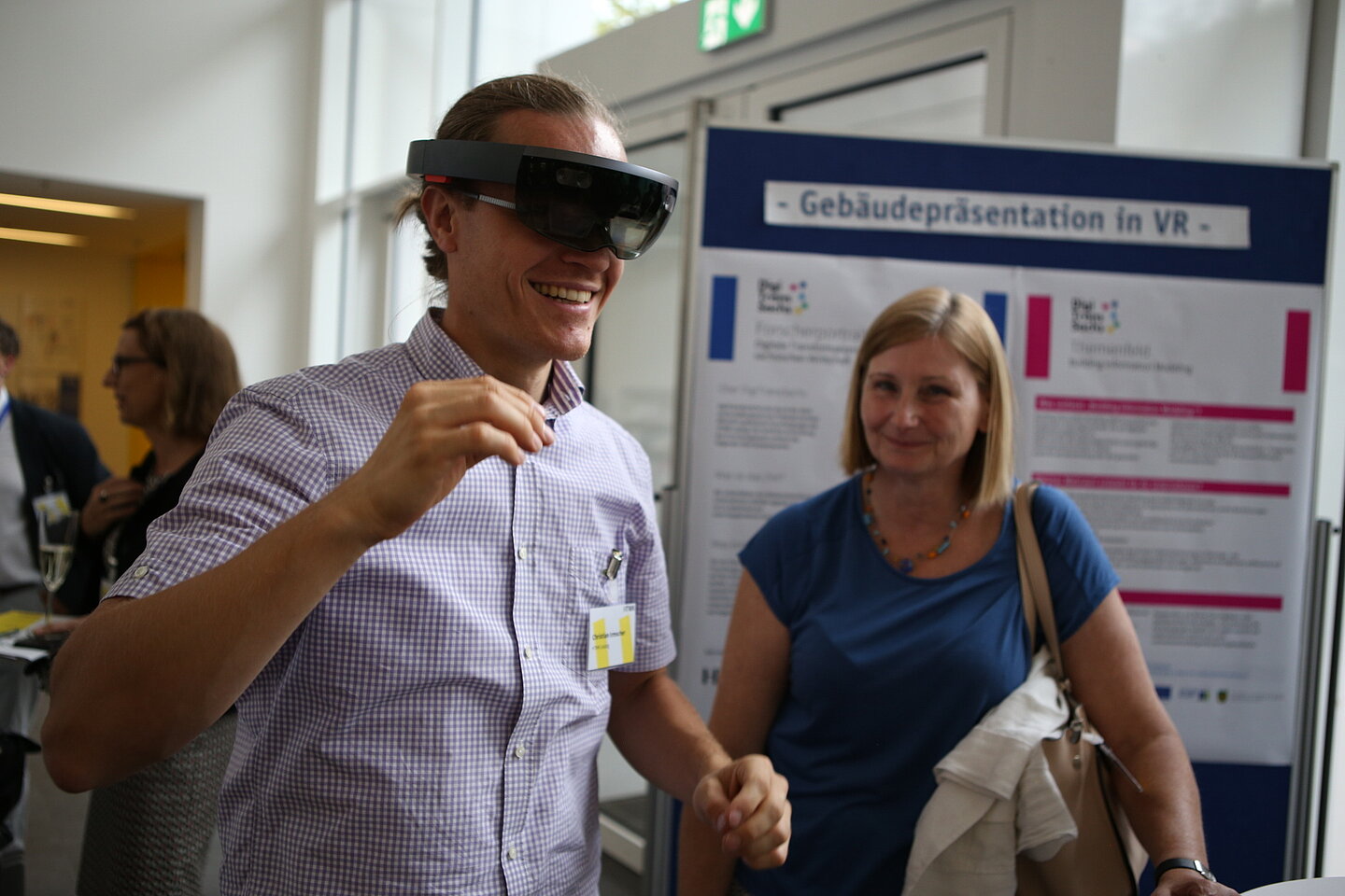 Christian Irmscher, Mitarbeiter der Fakultät Bauwesen, präsentiert Petra Förster, Leipziger Niederlassungsleiterin des SIB, die Anwendung digitaler Methoden im Bauingenieurwesen. Mann mit VR-Brille
