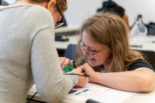 Nahaufnahme von zwei jungen Frauen, die an einem ArduinoChip arbeiten