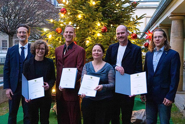 Berufungen 3.12.2025 Gruppe von sechs Personen steht vor großem Weihnachtsbaum