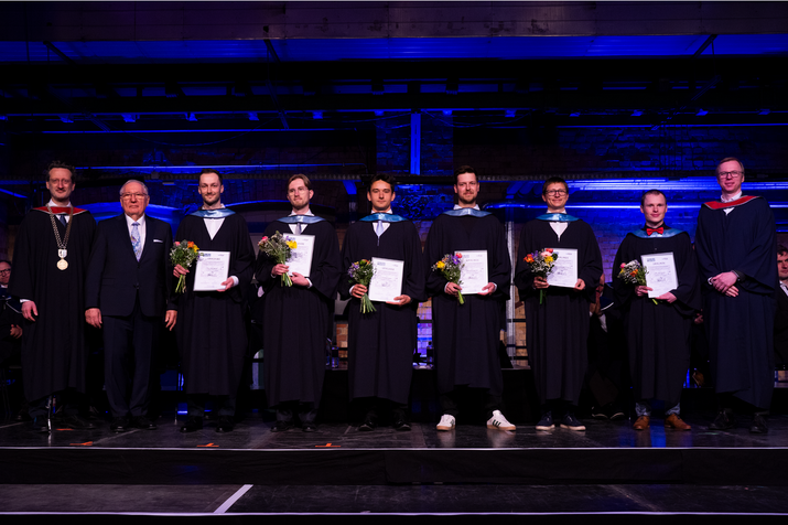 Gruppenfoto auf der Bühne, Preisträger halten Blumen und Urkunden in den Händen