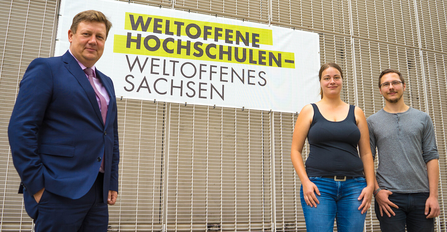 Weltoffen vor der Hochschule: Prorektor Prof. Markus Krabbes, Studierende Marie Hartung und Toni Nabrotzky (StuRa) (Foto: Stephan Thomas) Gemeinsam mit Prof. Markus Krabbes (Prorektor Forschung) stehen die HTWK-Studierenden Marie Hartung und Toni Nabrotzky (StuRa) vor dem soeben am Nieper-Bau platzierten Banner sinnbildlich für das Selbstverständnis der Einrichtung als „Weltoffene Hochschule“.