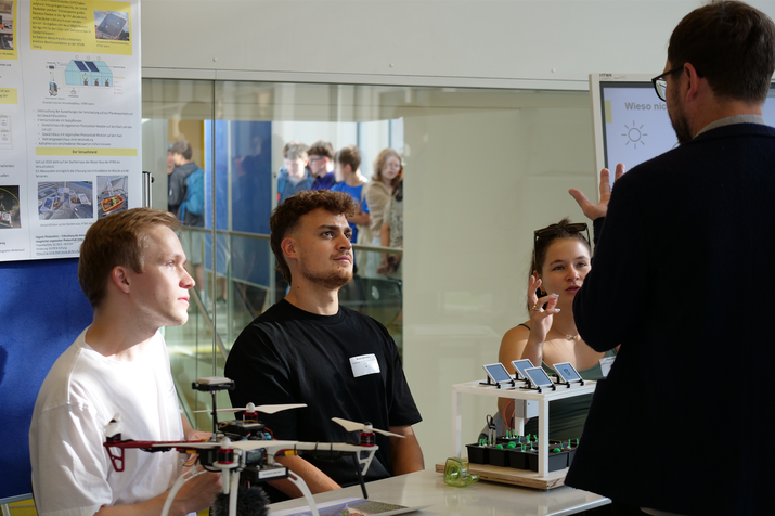 Mitarbeiter vom Projektteam sitzen mit Exponaten am Tisch