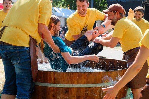 Dem Kornuten wird an diesem heißen Sommertag eine Abkühlung verpasst: Die Gehilfen tauchen die Kornuten 3 bis 5 Mal in ein Wasserfass.  