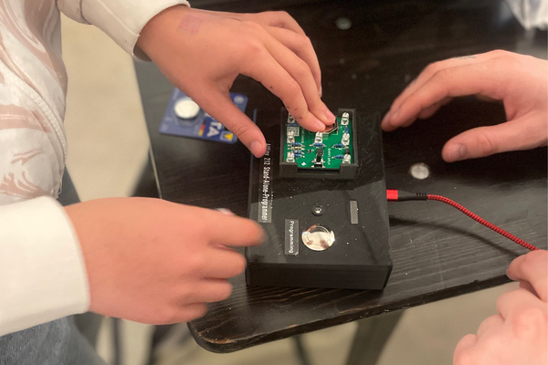 Nahaufnahme von Mikrocontroller und Händen, die daran arbeiten