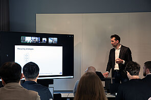 Dr. Sebastian Spitzer ein Mann hält einen Vortrag neben einem großen Bildschirm