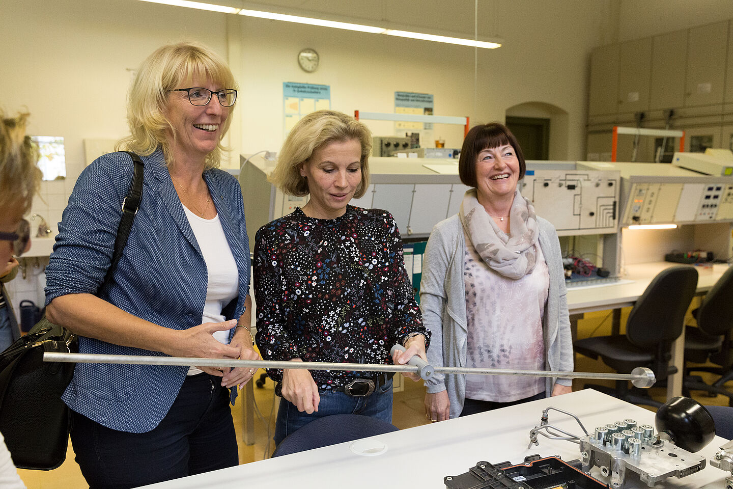 Eine Frau hält einen Stab in der Hand, der die Kraft, die für einen Newtonmeter gebraucht wird, erfahrbar macht.