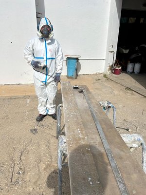 Outdoorküche aus recyceltem Rotorblatt Ein Mann in Schutzkleidung steht neben langen Brettern aus recyceltem Rotorblatt