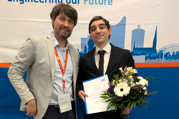 Portraitfoto und Preisträger hat Urkunde und Blumen in der Hand