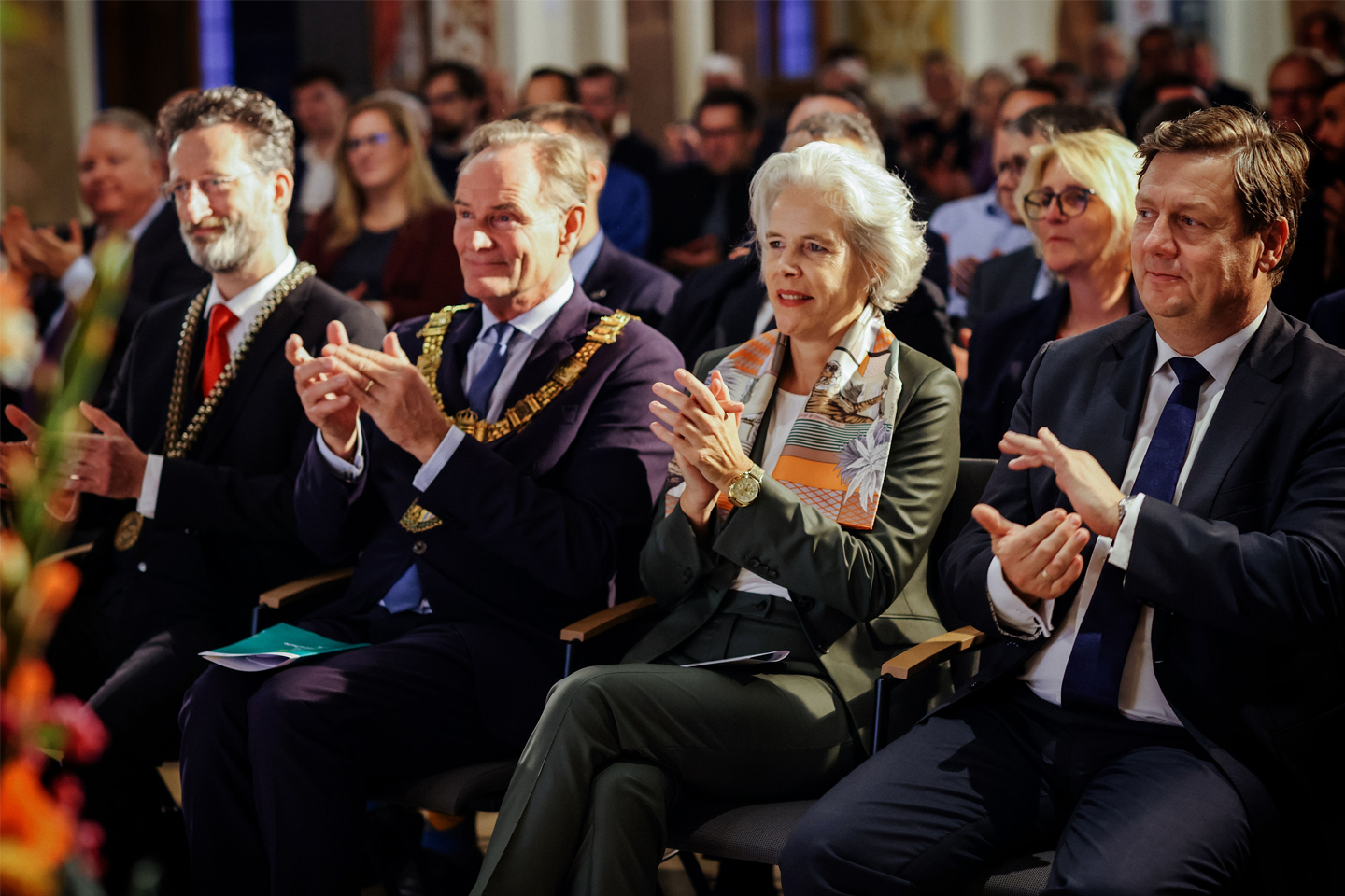 Foto der ersten Sitzreihe, Personen klatschen