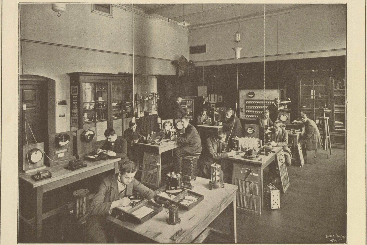 Black and white photograph of the laboratory with students at individual tables with electronic boxes