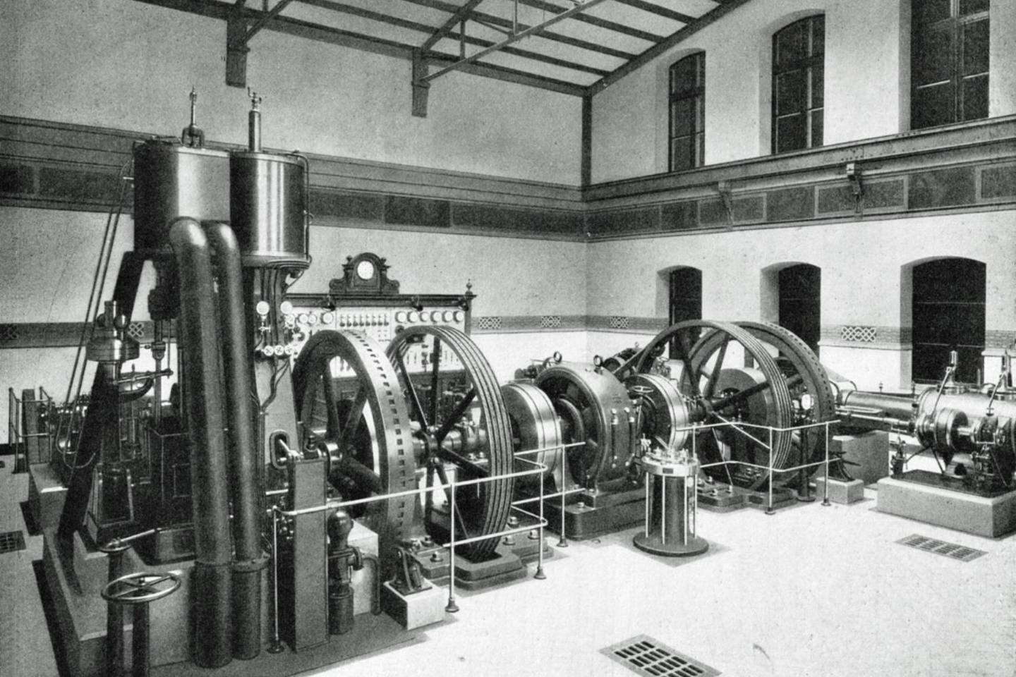 black and white photograph showing huge gears on the floor in a large room