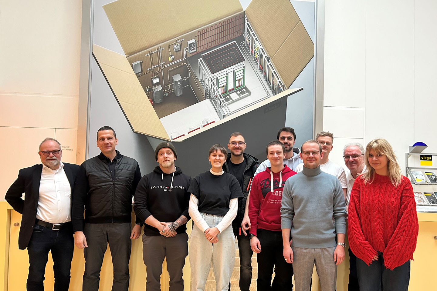Gruppenfoto, im Hintergrund Skizze an Wand und Viega-Logo