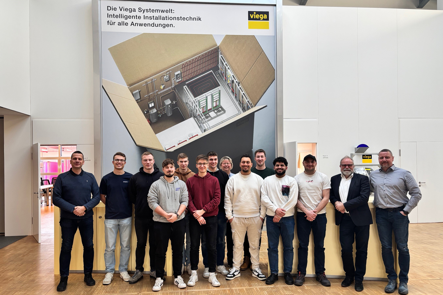 Gruppenfoto, im Hintergrund Skizze und Viega-Logo
