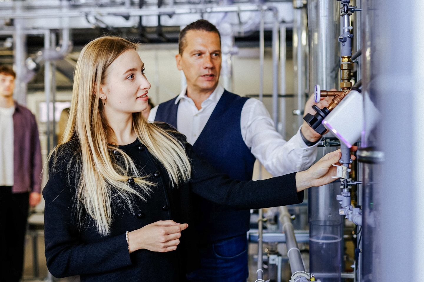 In the foreground, a young woman; behind her, the professor—inside the water tower, working on pipes, Prof. Guzek explains how it works
