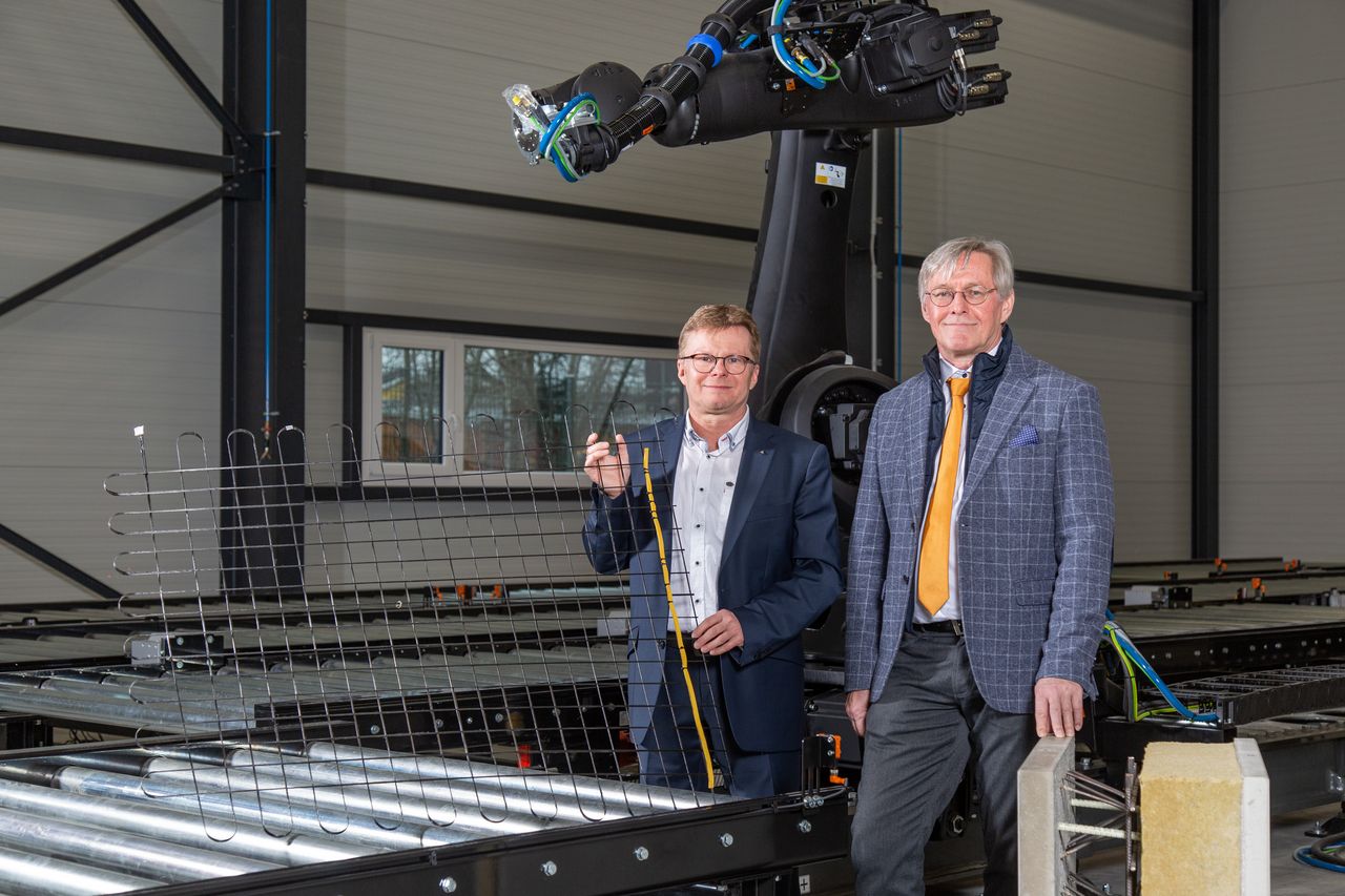 Professors holding a carbon-concrete composite in an industrial hall / Link leads to the project website