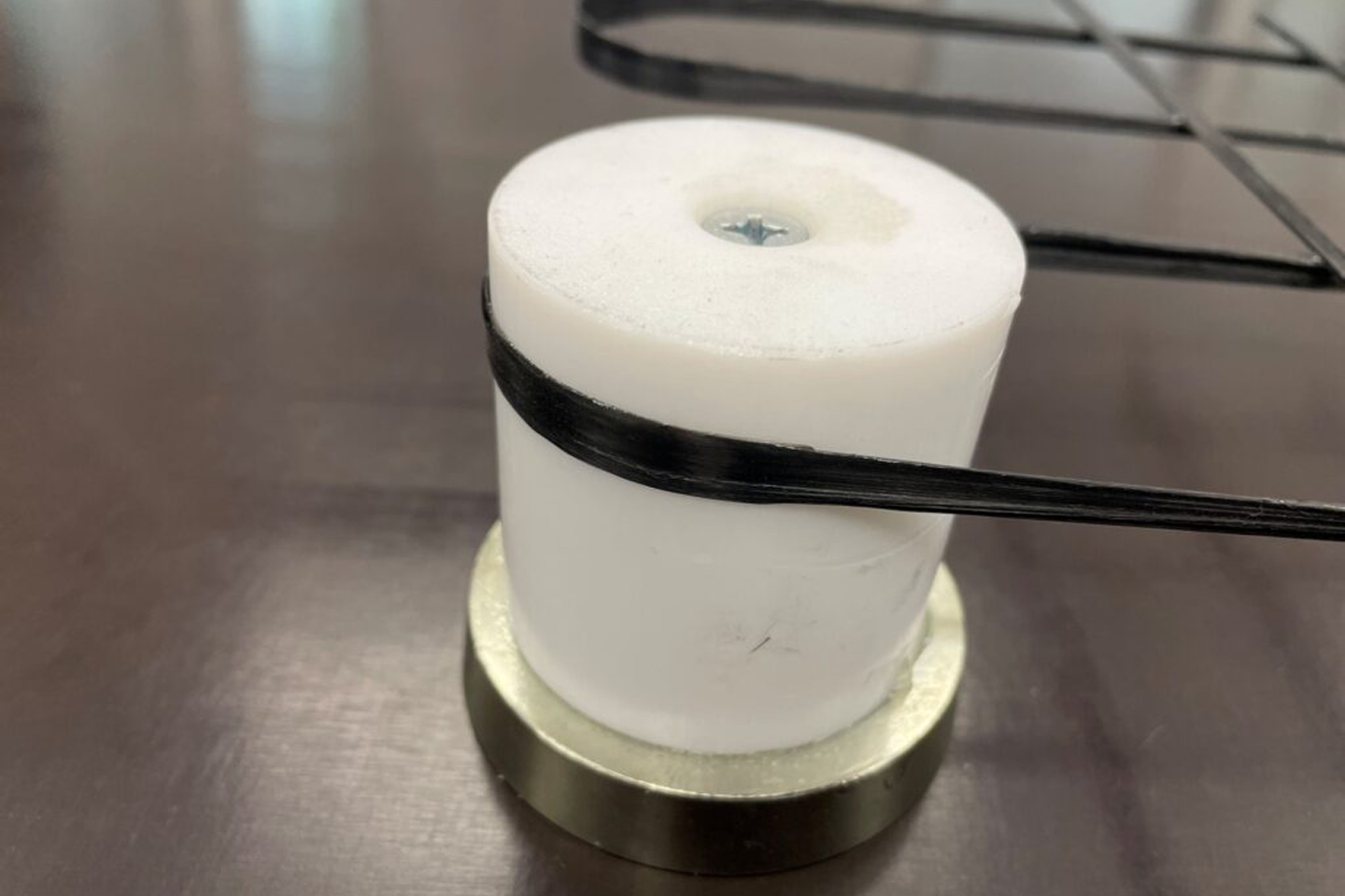 Close-up of a white spool with black yarn wound around it; when clicked, the link takes you to the project website