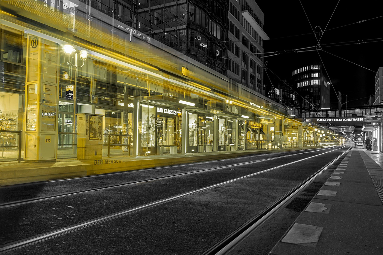 Street at night, yellow stores on the left, streetcar tracks in the center / link leads to the project website