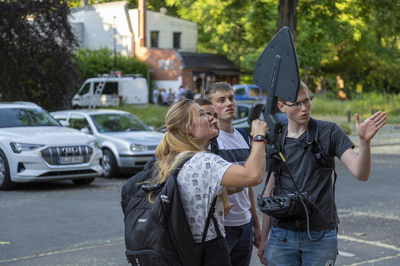Studierende suchen mit einem Handpeilempfänger eine Störquelle auf