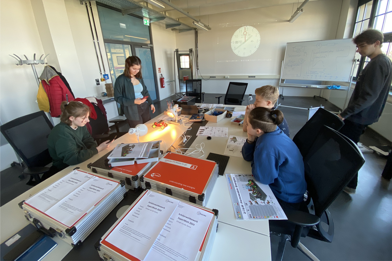zwei Schüler messen an Solarzellen die Sonnenergie unter Anleitung Dozentin und Dozenten