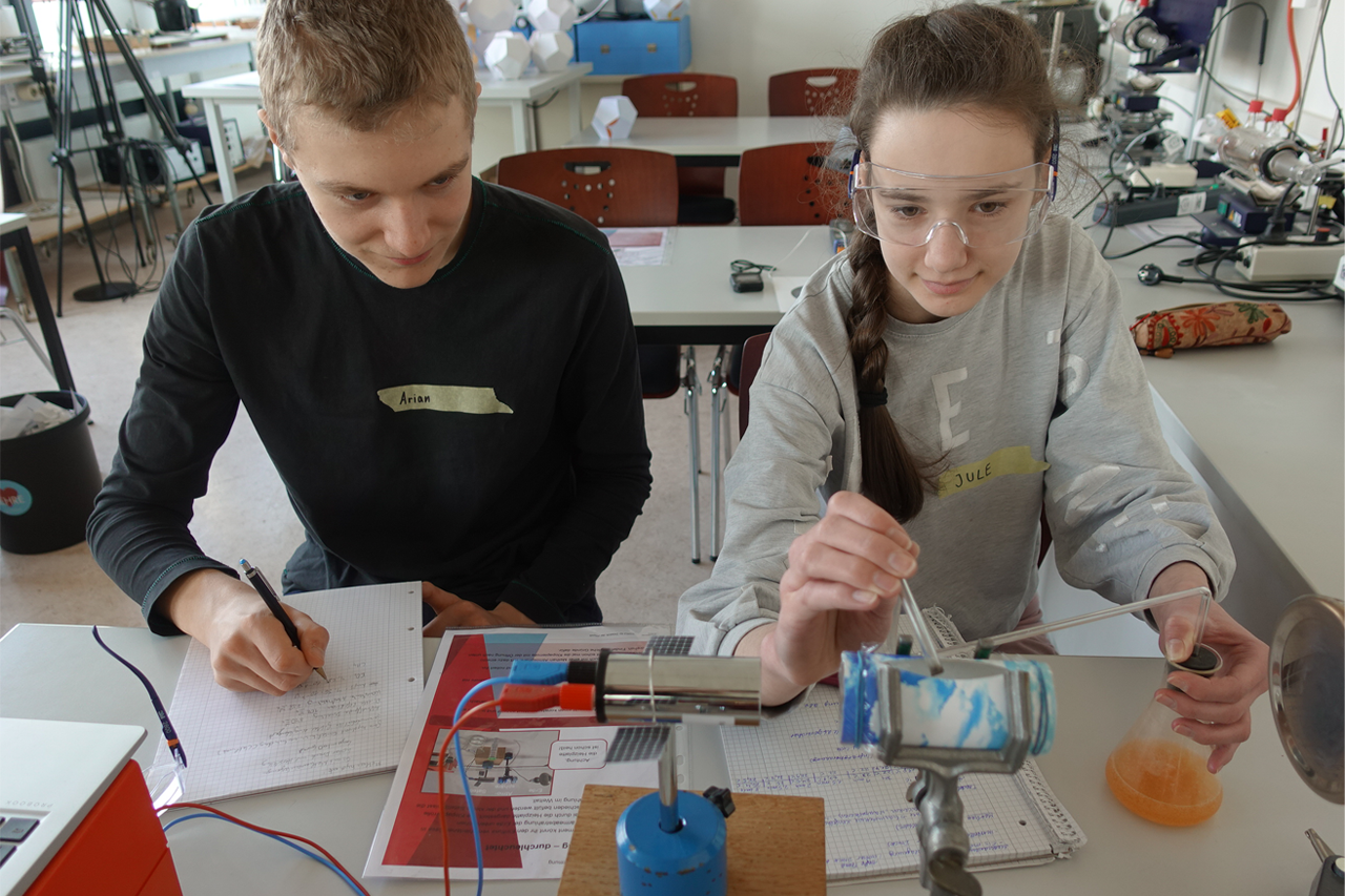 Schüler und Schülerin an der Universität Leipzig beim Experiment