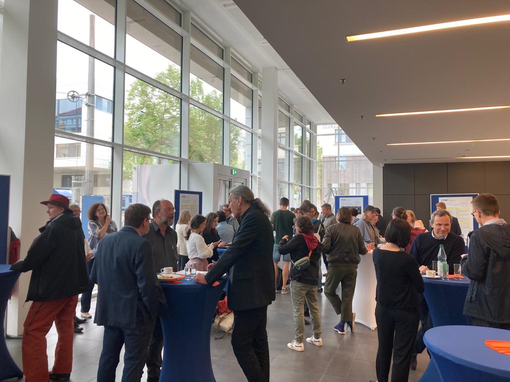 Leute an Stehtischen in großem Foyer